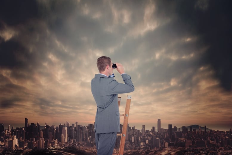 Businessman looking on a ladder against dusty path leading to large city.jpeg